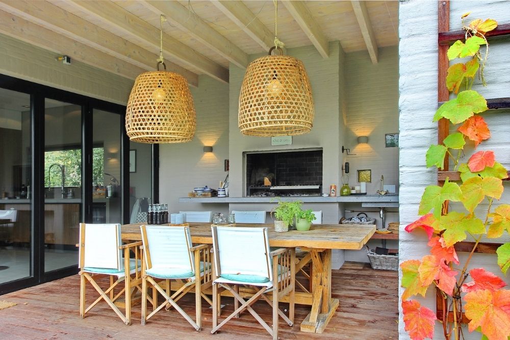 Buitenruimte met eetset en grote rieten lampen