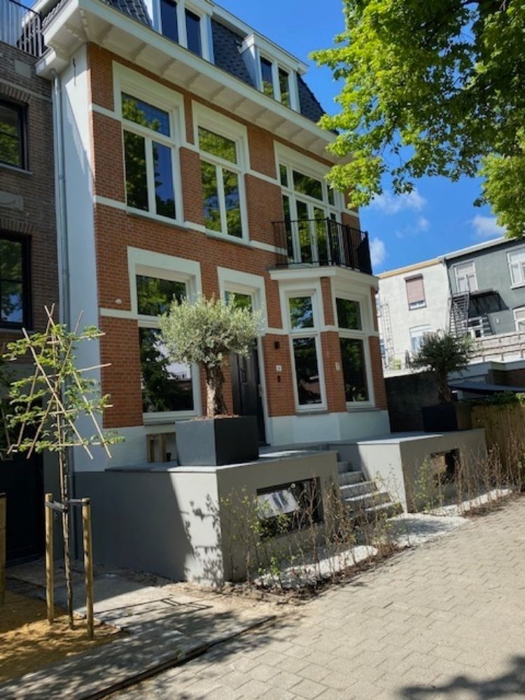 Een hoog woongebouw aan een zonnige straat