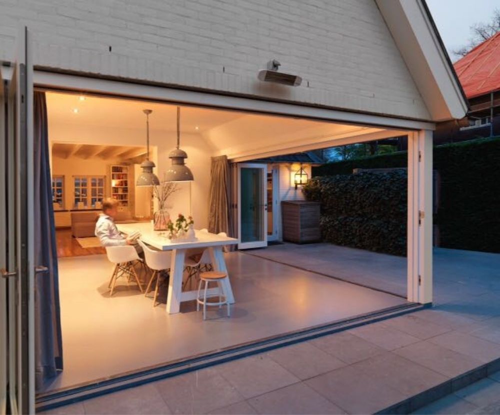 Eettafel met stoelen in een open garage bij warm avondlicht