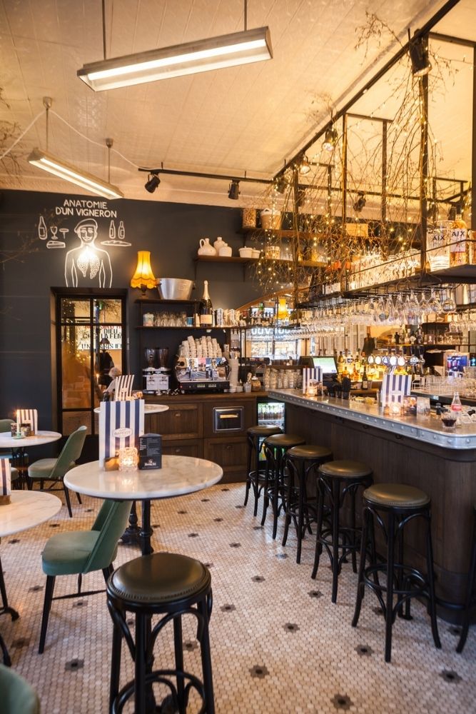 Gezellige bar met hoge krukken warme verlichting en gedekte tafels in een knus restaurant