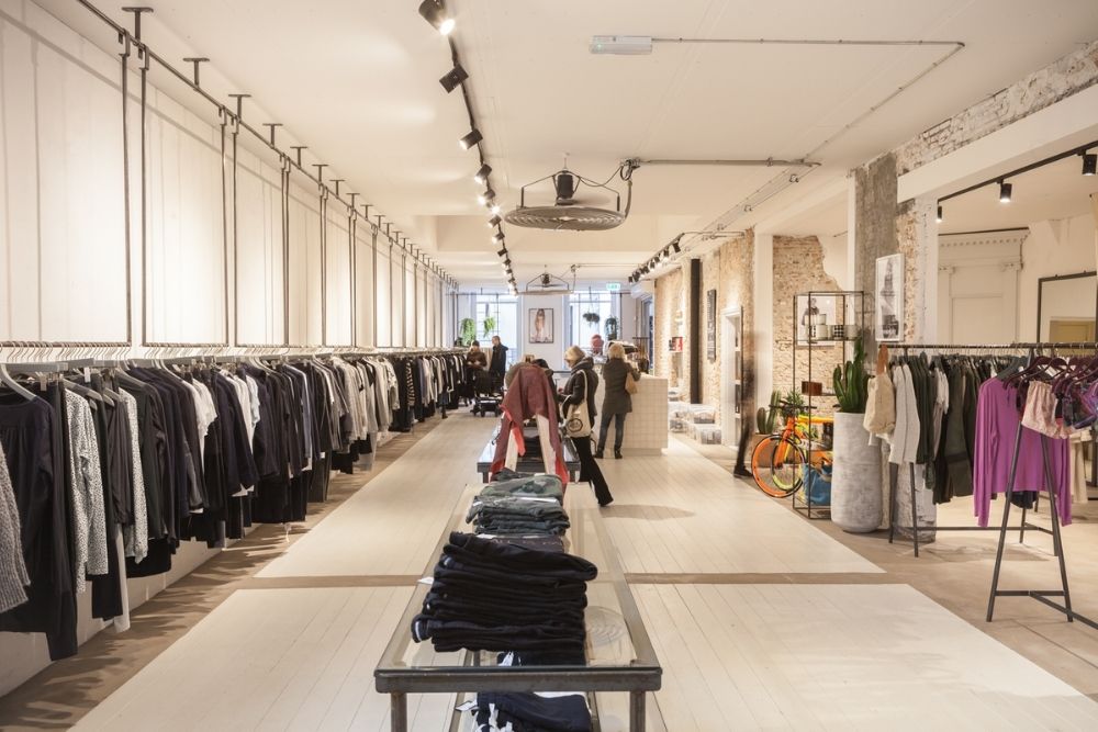 Interieur van een lichte winkel met hangende kleding