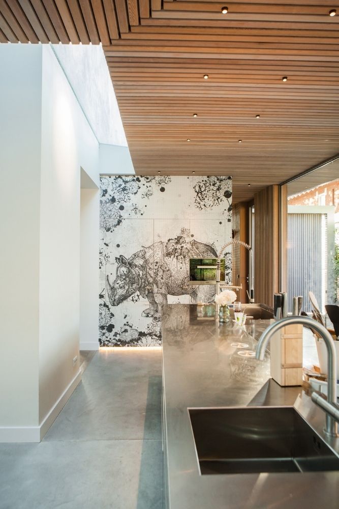 Moderne keuken met groot kookeiland en opvallende wanddecoratie