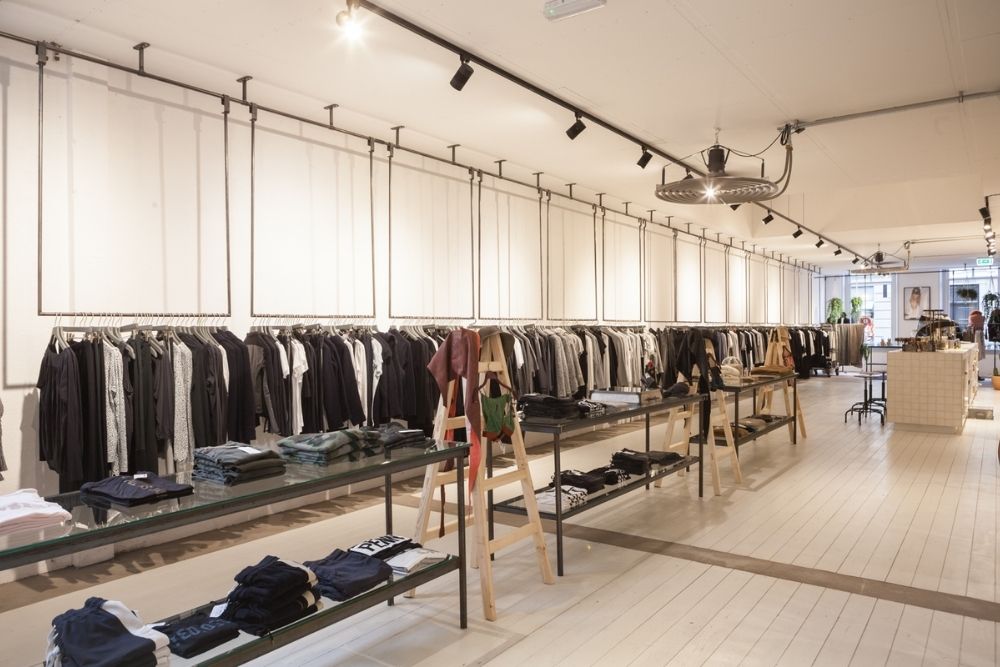 Moderne kledingzaak met rekken en tafels vol mode items