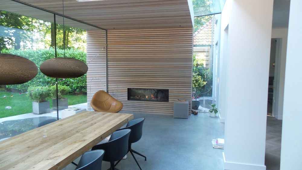 Moderne ruimte met houten tafel stoelen en zicht op tuin