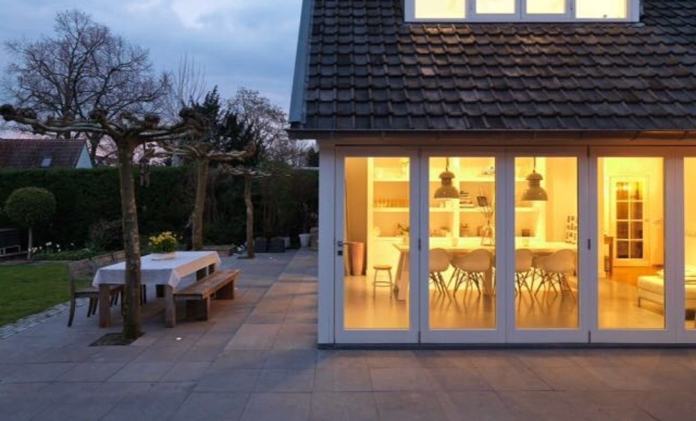 Moderne woning met grote ramen en een buitenterras met tafel