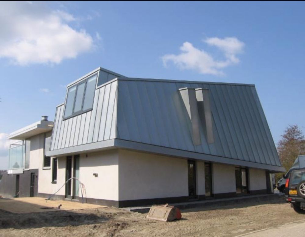 Huis met schuine metalen gevel en heldere blauwe lucht